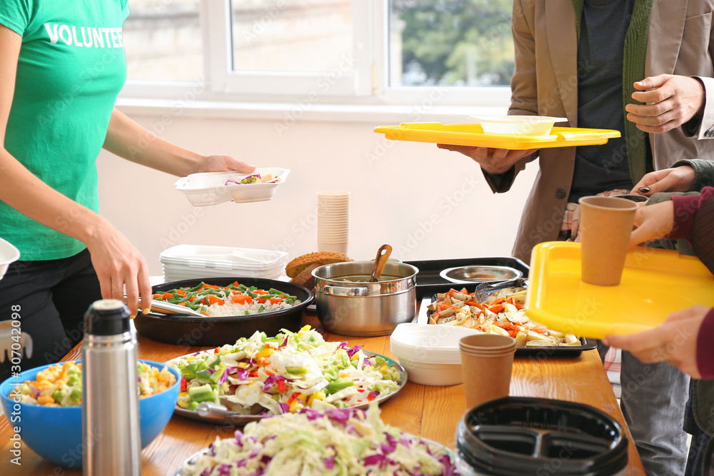 Volunteers giving food to homeless people