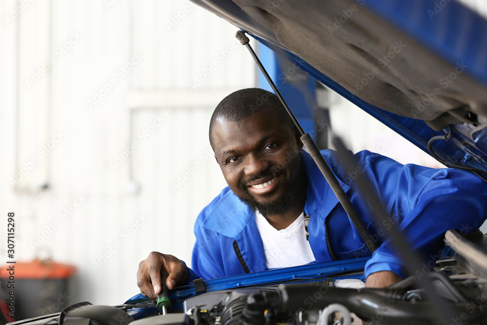 African-American mechanic working in car service center