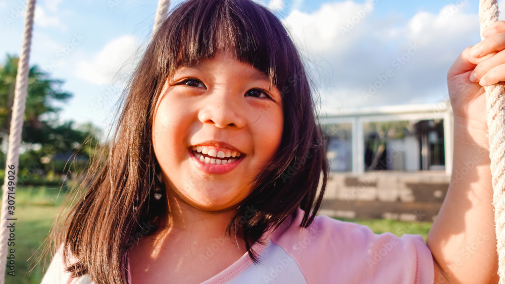 5 years old.Asian child girl playing on playground in outdoor park.Happy Little asian girl playing s