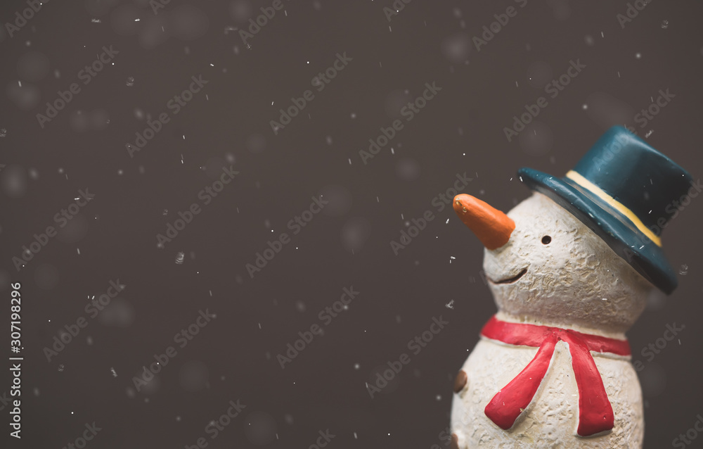 Happy smiley snowman wear blue hat and carrot nose standing with snowflakes in winter christmas seas