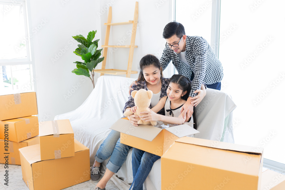 asian people and daughter holding bear doll, children unpacking paper box,  they clear and decorate 