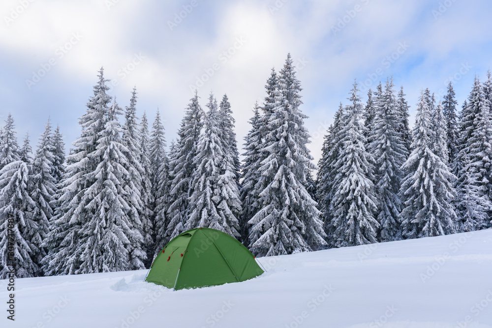 Green tent in winter mountains