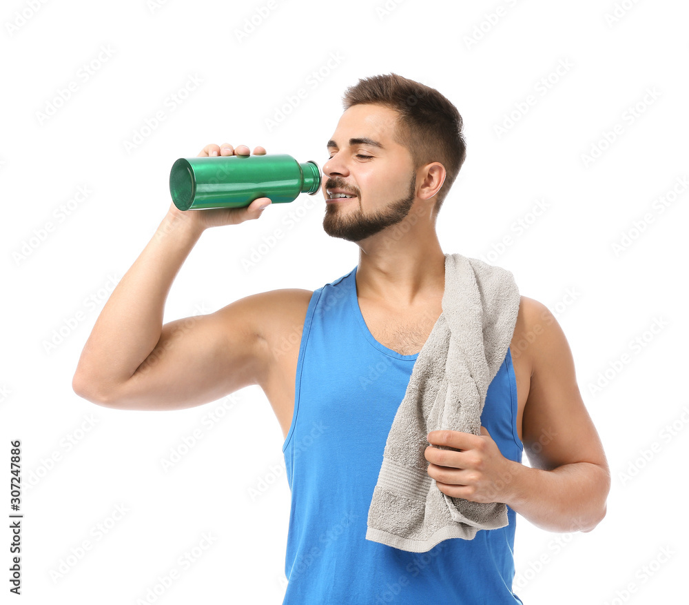 Sporty young man with towel and bottle of water on white background