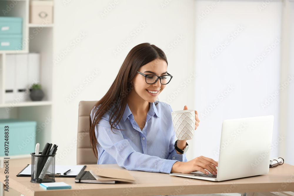 Beautiful young businesswoman working in office