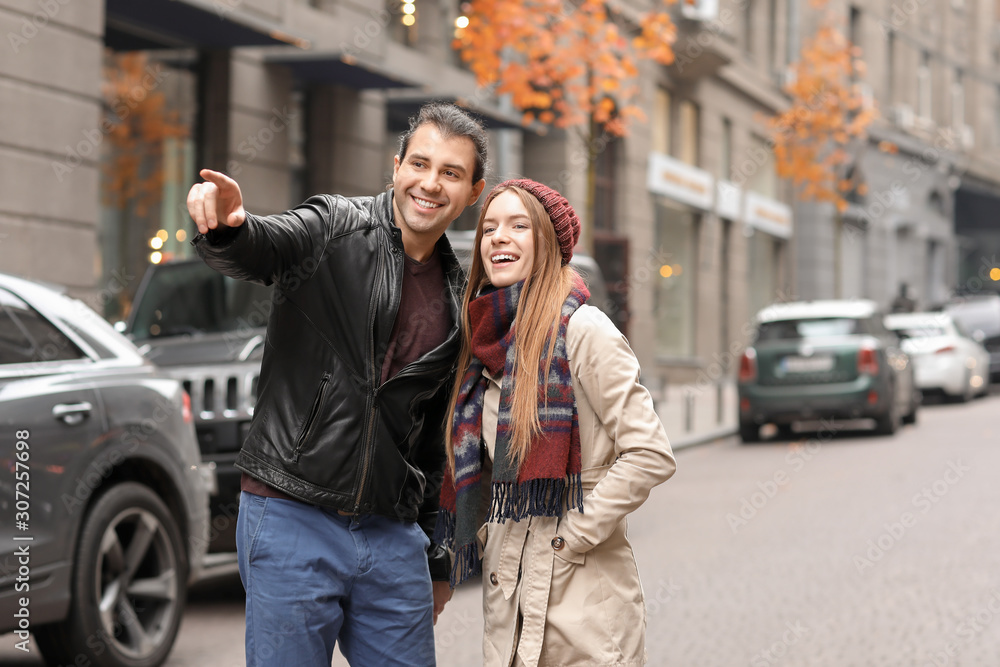 Happy couple walking in autumn city