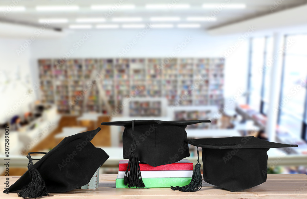 Mortar boards and books on table. Concept of high school graduation