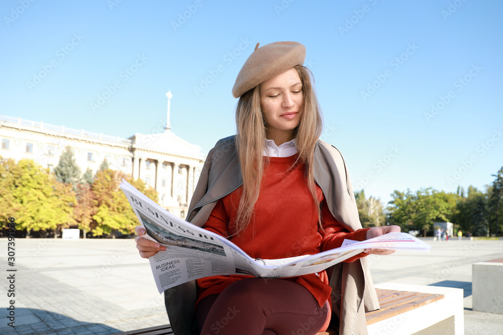 户外拿报纸的年轻女人