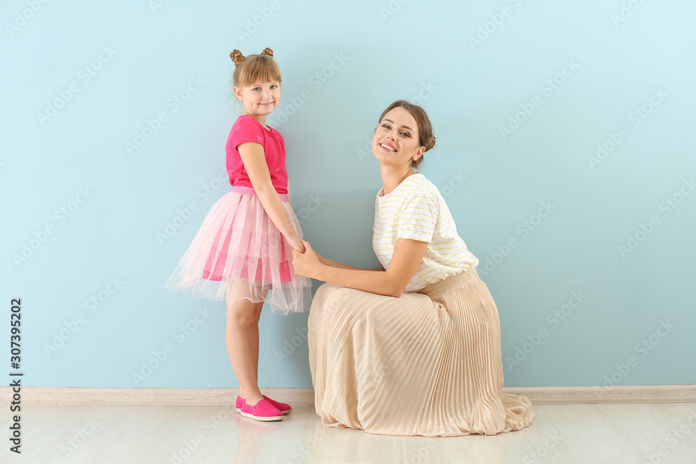 Portrait of happy mother and daughter on color background