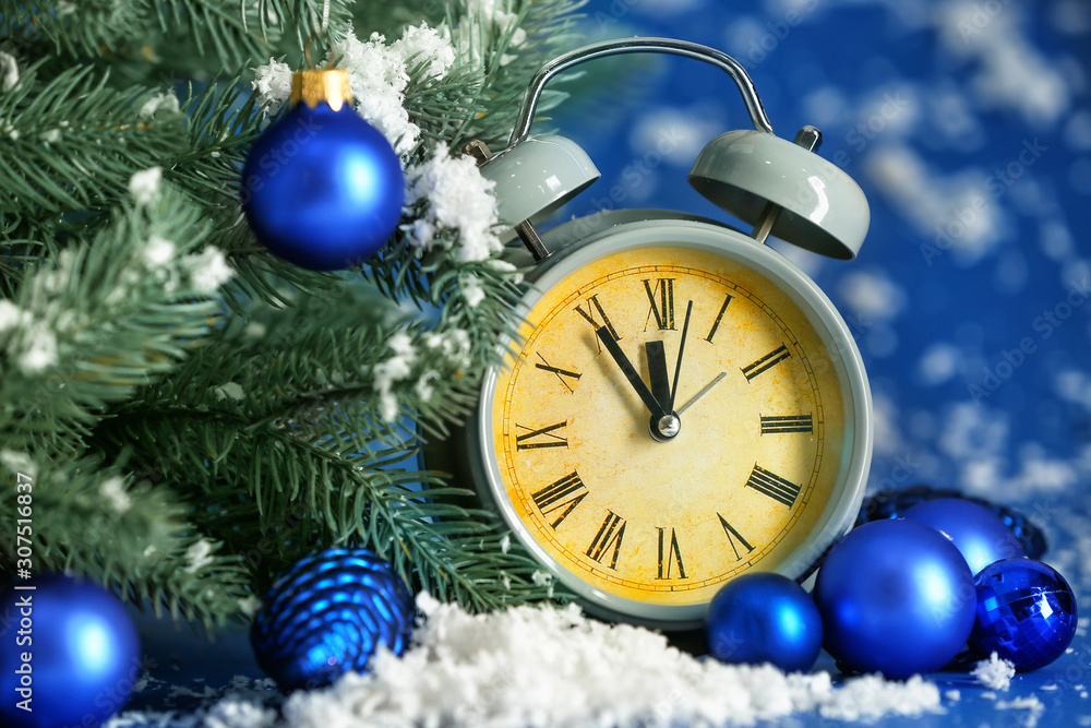 Alarm clock, fir tree and snow on color background. Christmas countdown concept