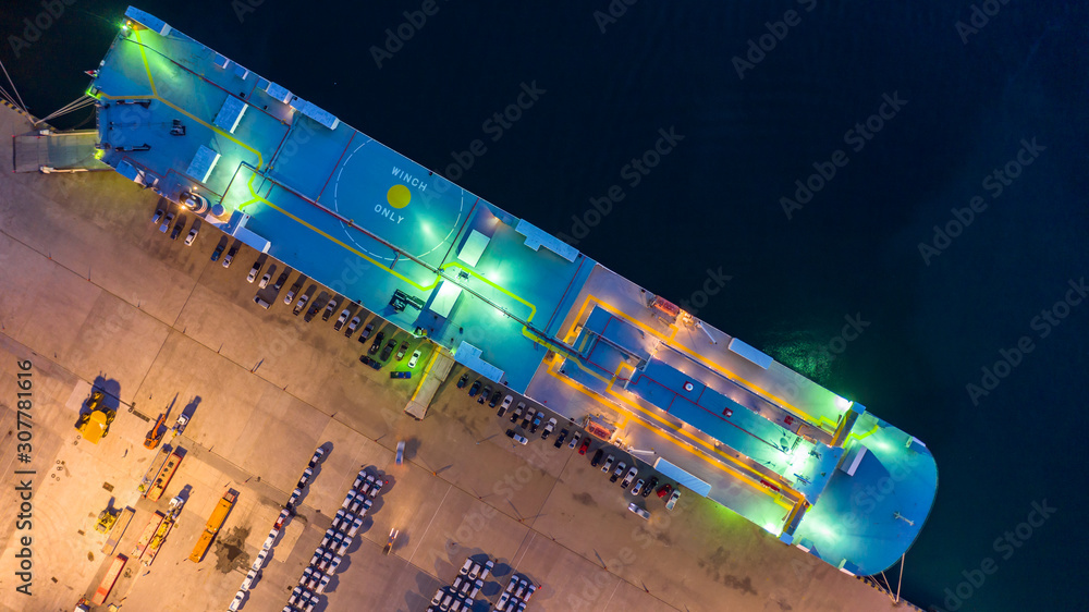 Aerial top view car carrier vessel at night, rows of new cars at night waiting to be dispatch and sh