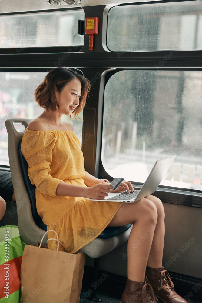 Young businesswoman on a business travel. Working on the bus using her laptop.