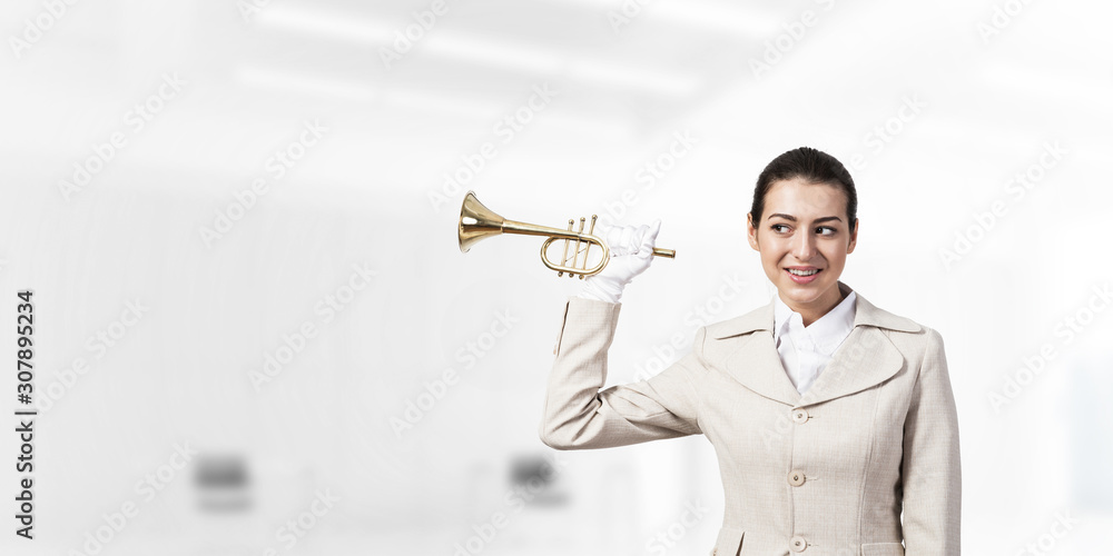 Beautiful woman holding trumpet brass near ear