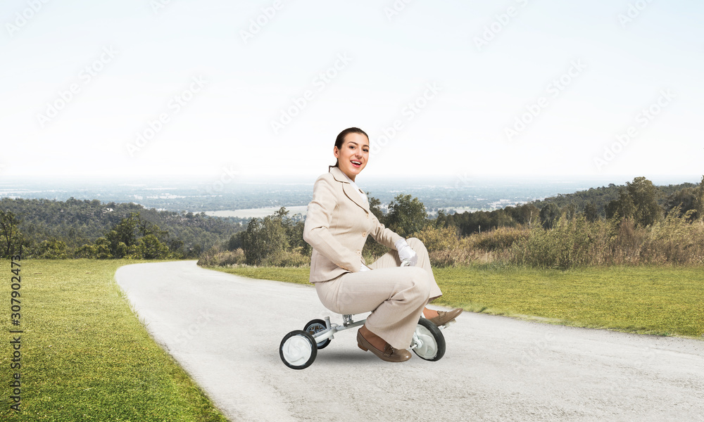 美丽快乐的女人骑着儿童自行车