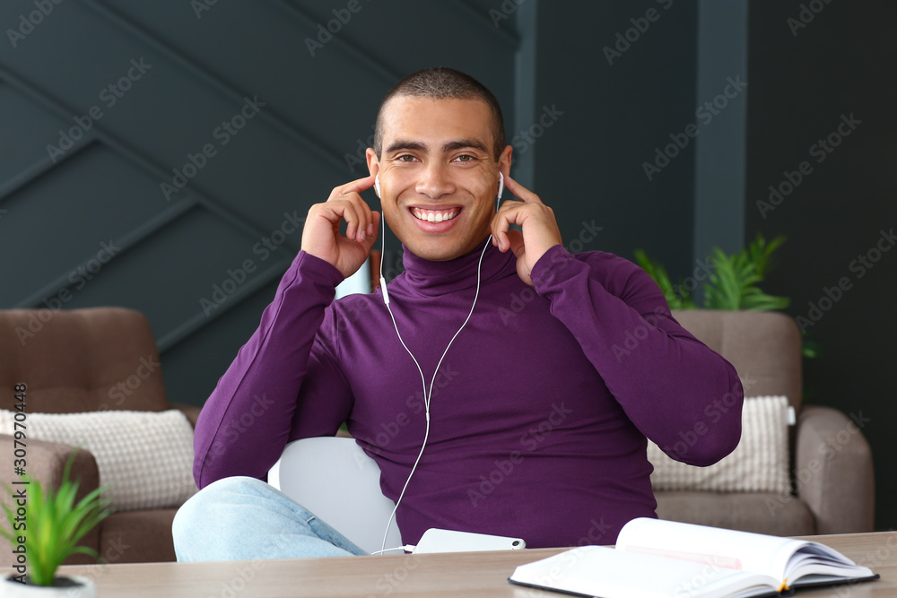 Portrait of handsome young man listening to music at home