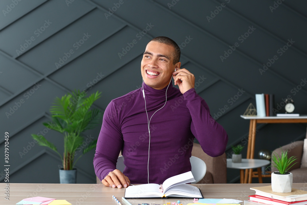 Portrait of handsome young man listening to music at home