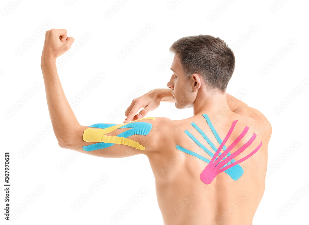 Sporty man with applied physio tape on body against white background