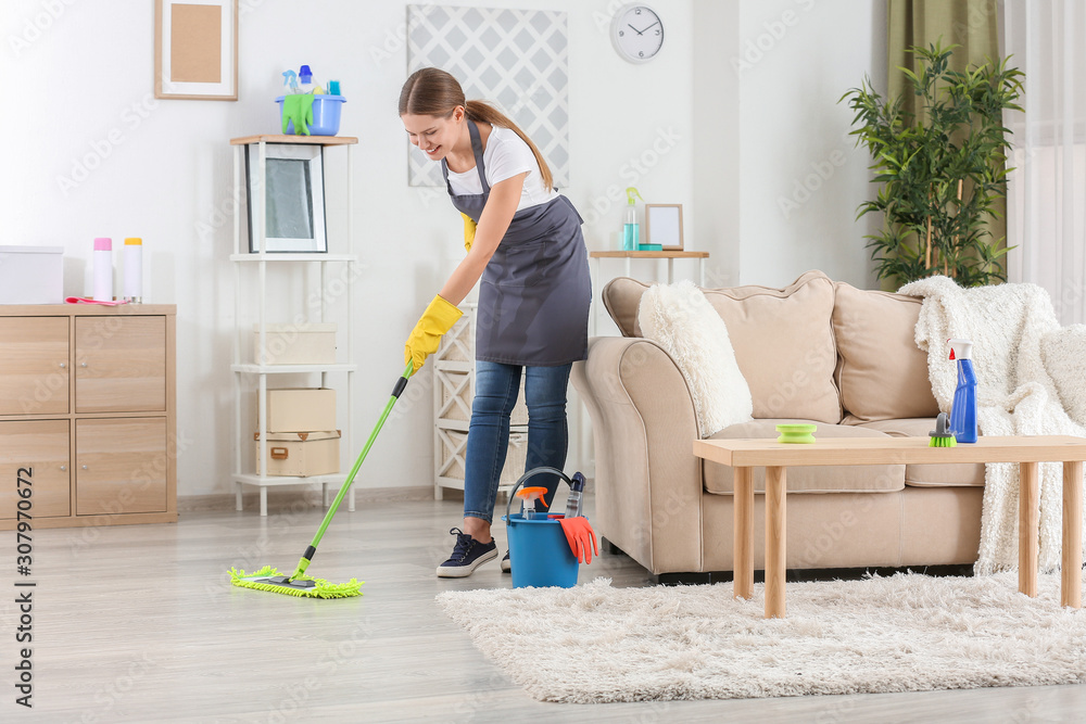 Female janitor mopping floor in room