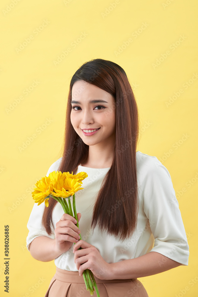 幸福的年轻女子手中拿着一束黄色背景的鲜花