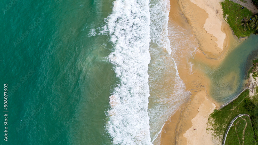 Tropical sea and wave crashing on sandy shore at karon beach in phuket thailand aerial view drone ca