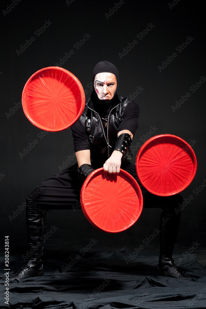 Actor juggles with big red plates