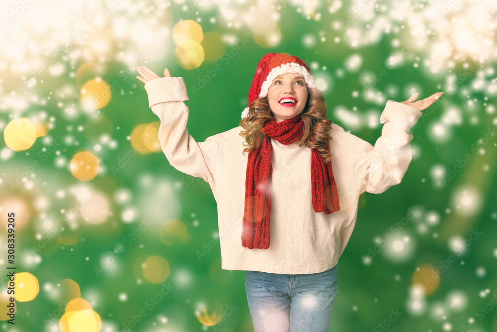 Happy young woman in winter clothes on color background with snow