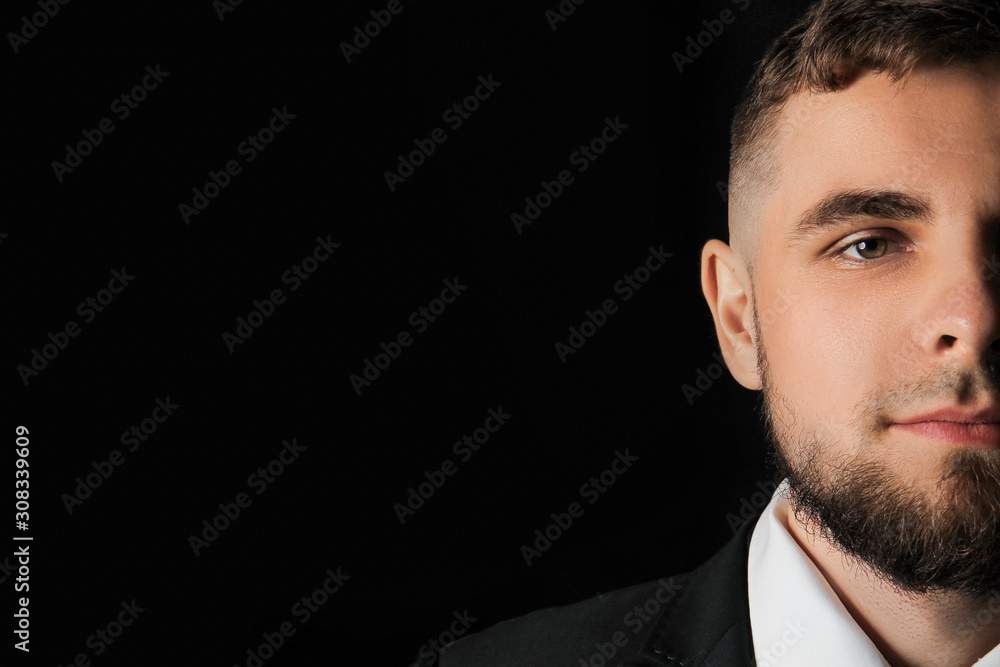 Handsome young businessman on dark background