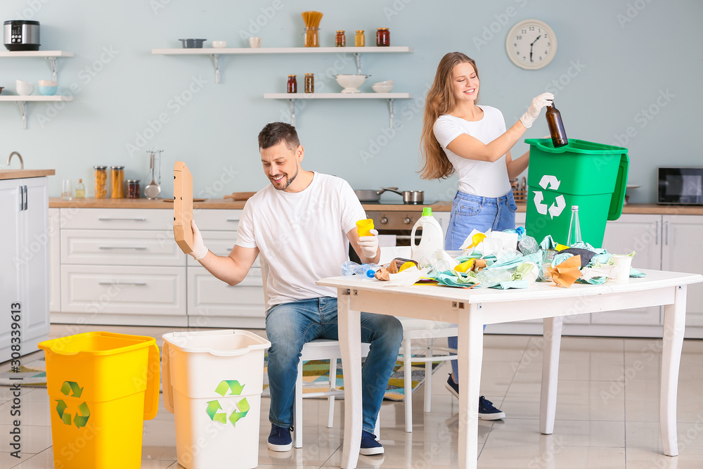 Couple sorting garbage at home. Concept of recycling