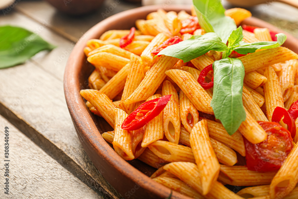 Plate with tasty pasta on wooden table, closeup