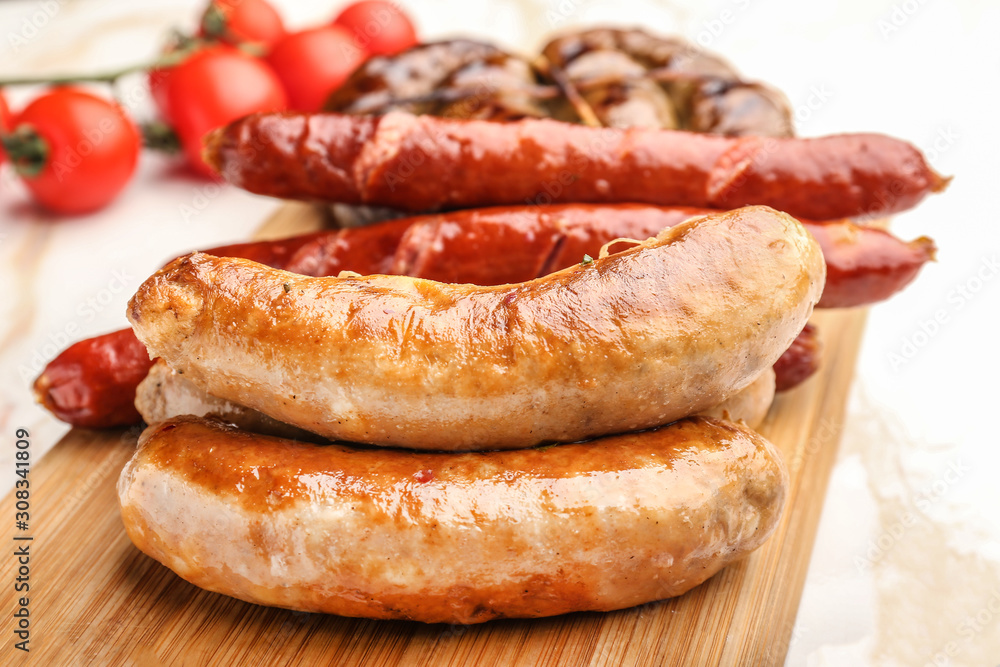 Tasty grilled sausages wooden board, closeup