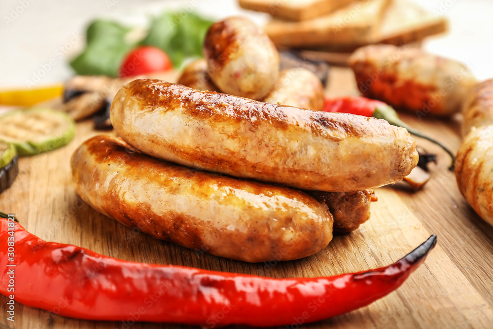 Tasty grilled sausages wooden board, closeup