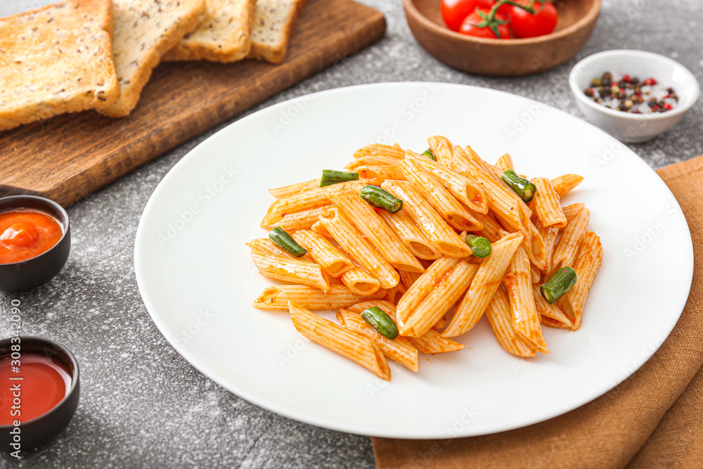 Plate with tasty pasta on table