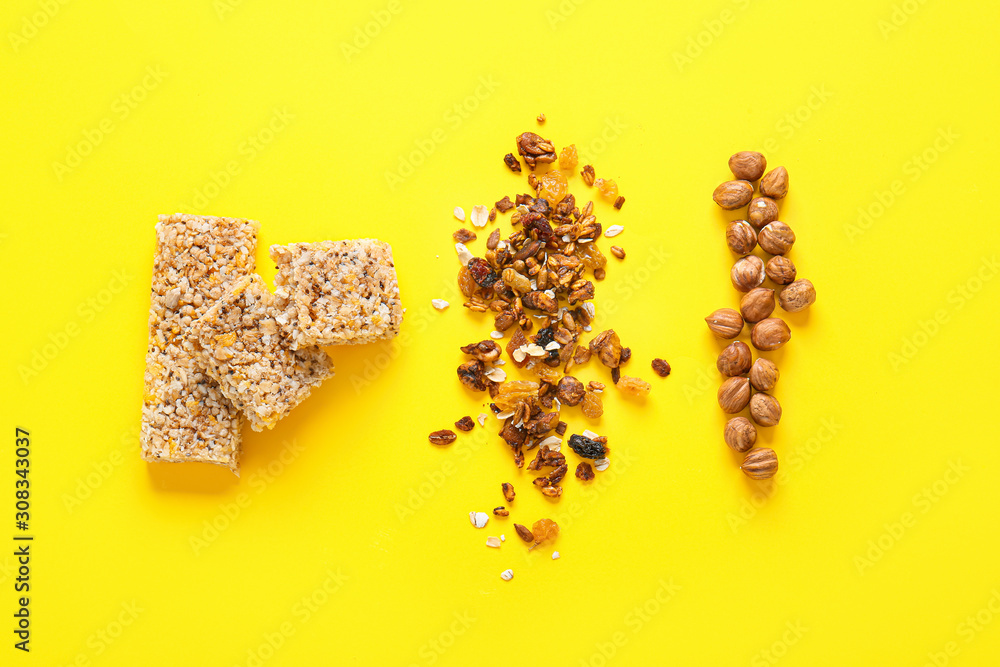 Tasty granola bars with ingredients on color background