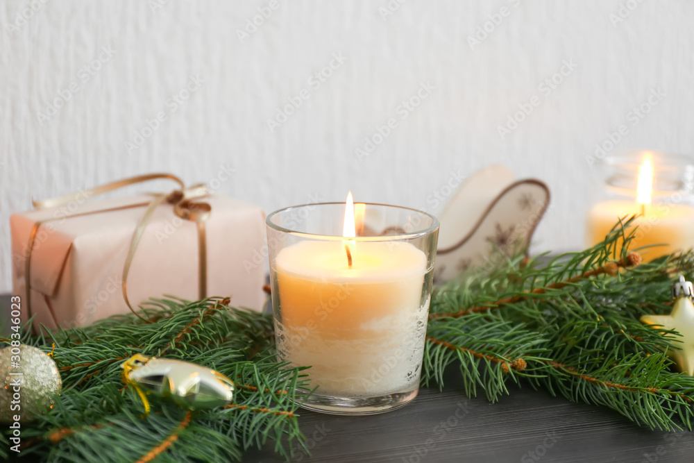 Beautiful burning candles, Christmas decor and fir branches on table