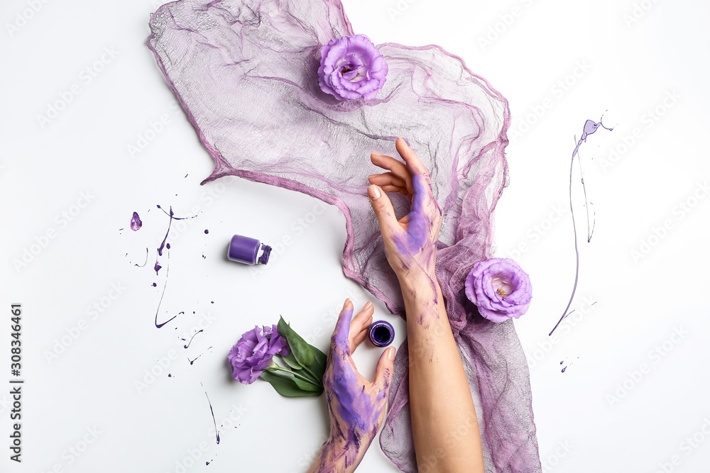 Artists hands in paint, flowers and cloth on white background