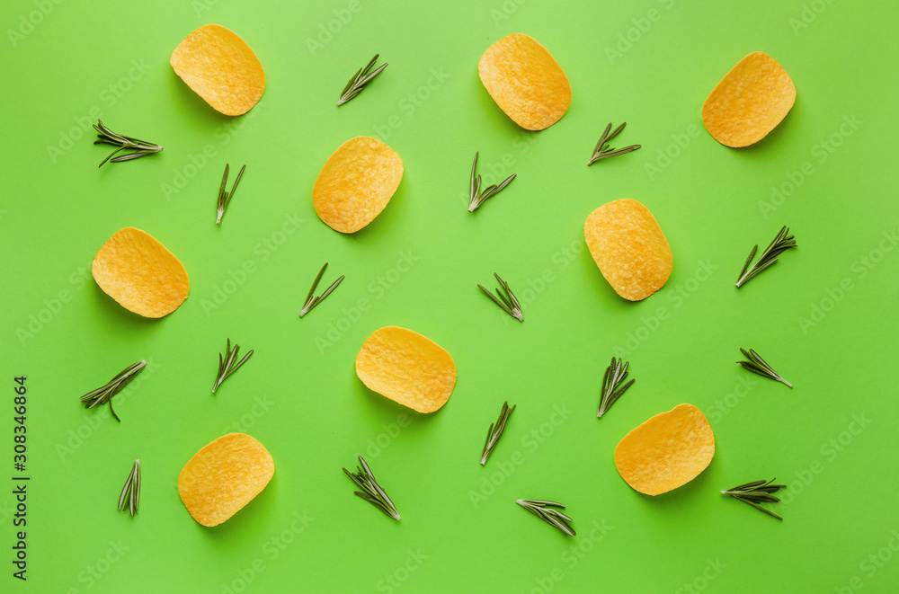 Tasty potato chips and herbs on color background