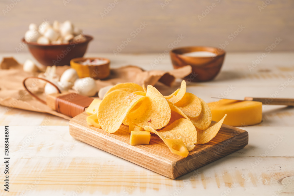 Tasty potato chips with cheese on table