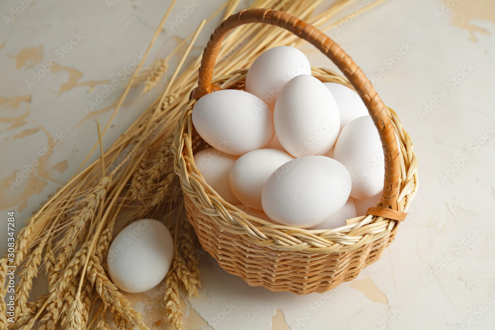 Basket with fresh raw eggs on table