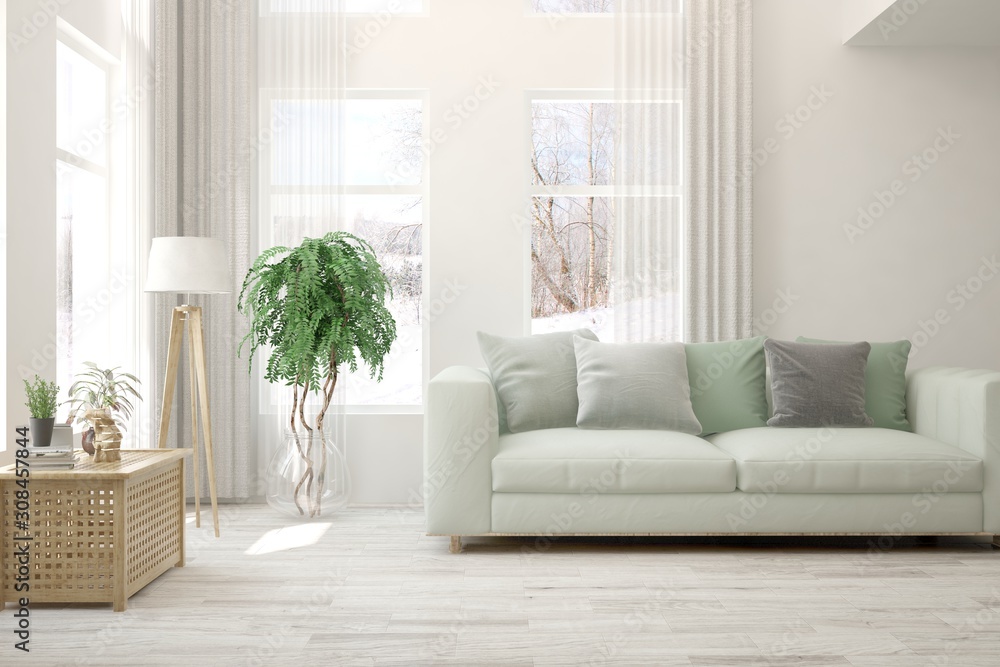 Stylish room in white color with sofa and winter landscape in window. Scandinavian interior design. 