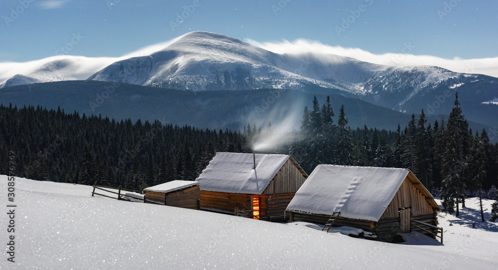 Fantastic night landscape glowing by moon light. Dramatic wintry scene with snowy house. Christmas h