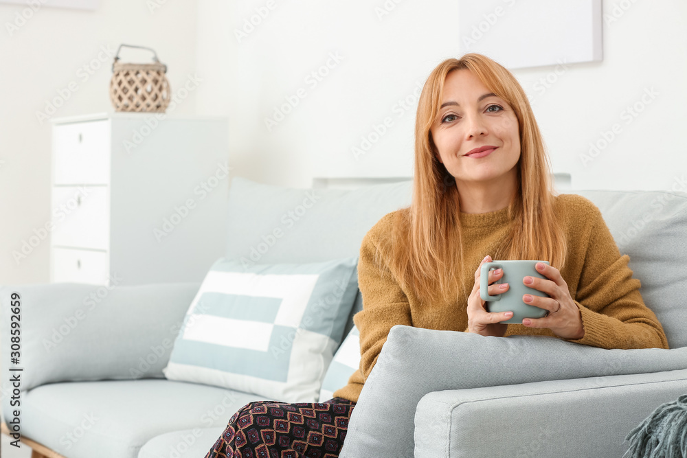 Beautiful mature woman drinking coffee at home