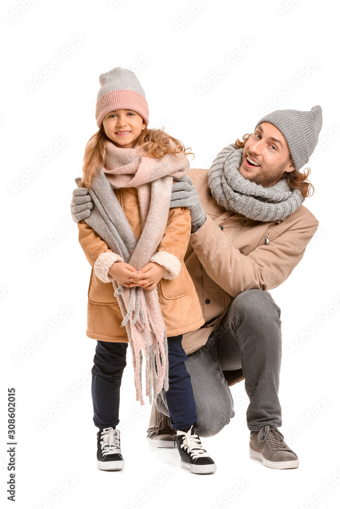 Handsome man and his little daughter in winter clothes on white background