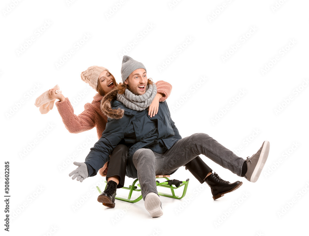 Happy couple in winter clothes and with sledges on white background