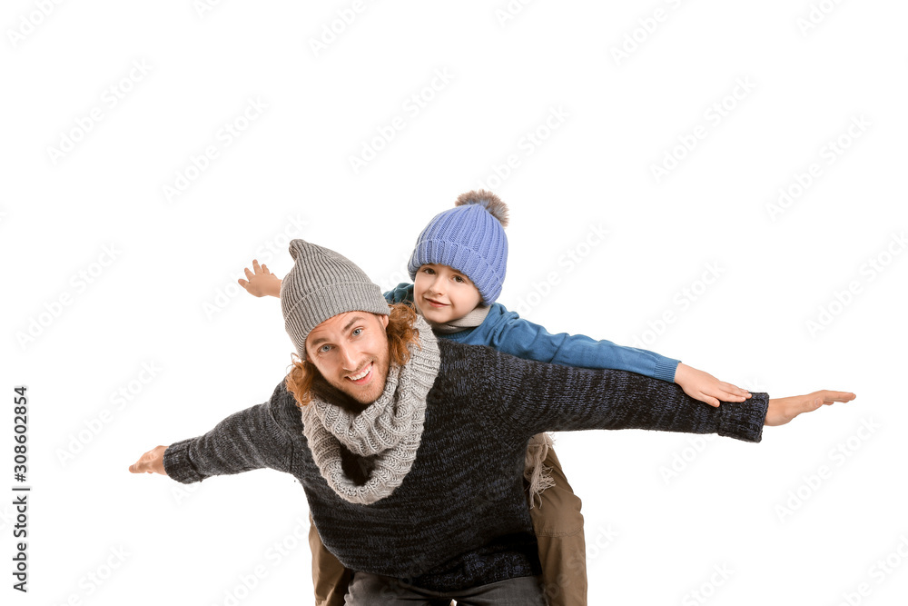 Handsome man and his little son in winter clothes on white background