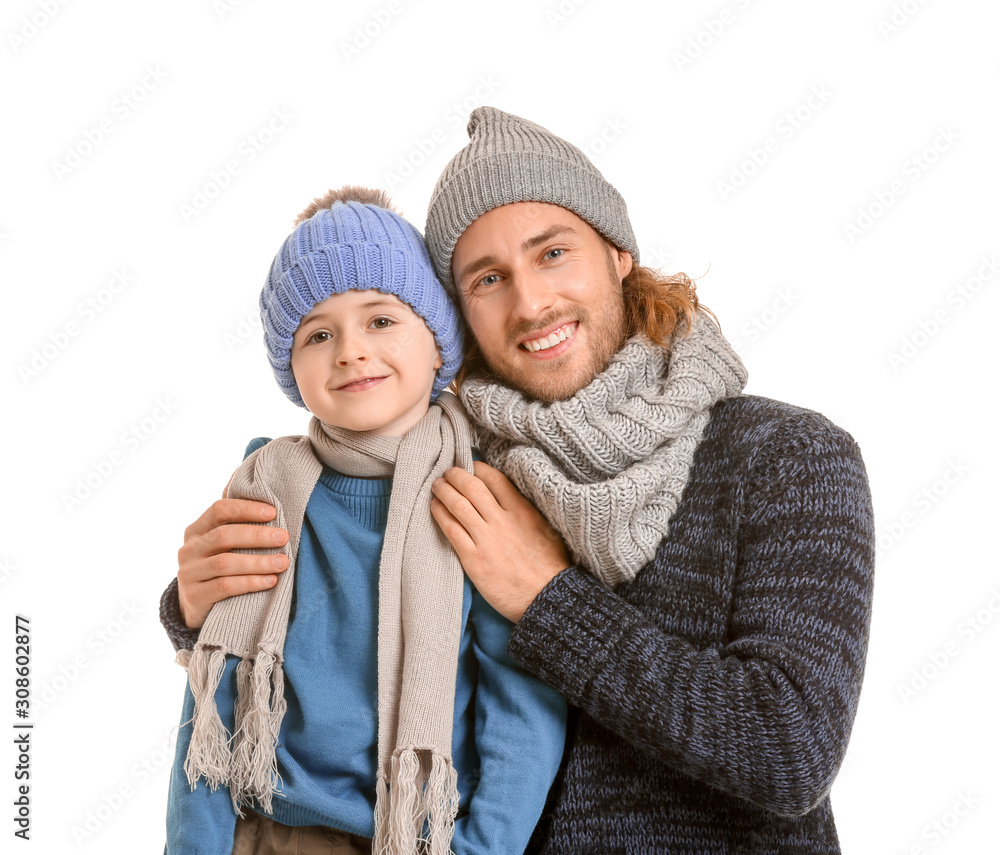 Handsome man and his little son in winter clothes on white background