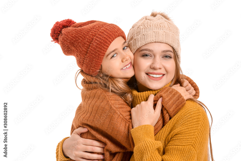 Woman and her little daughter in winter clothes on white background