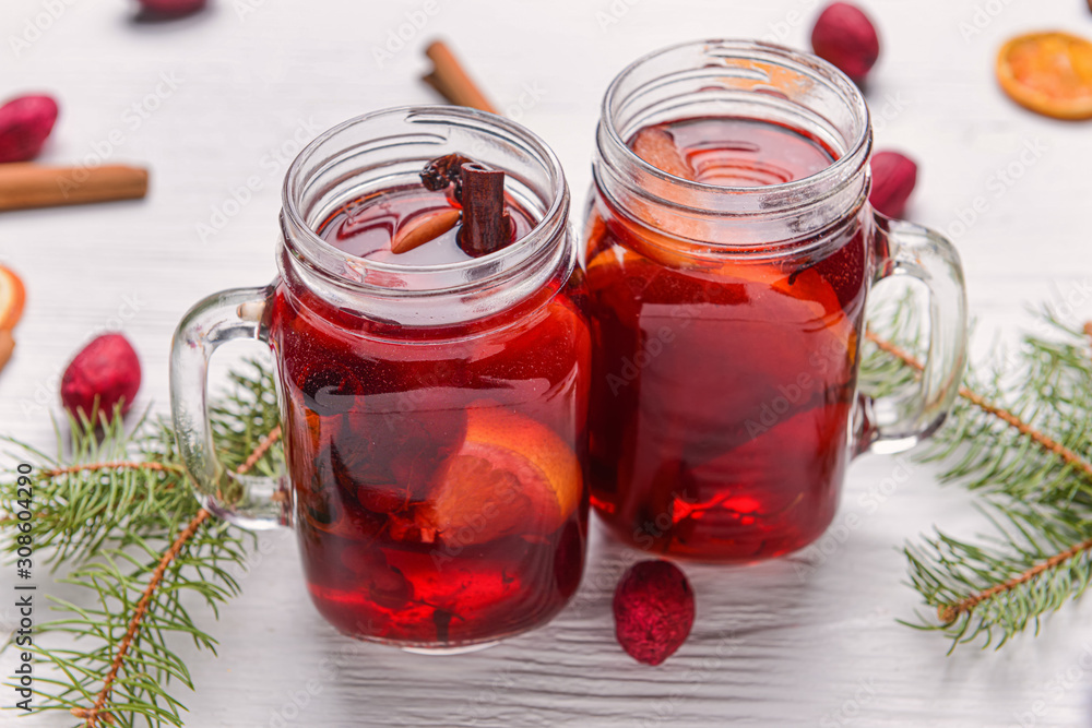 Mason jars of tasty mulled wine on white table