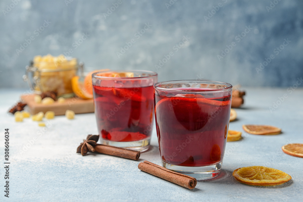 Glasses of tasty mulled wine on color background