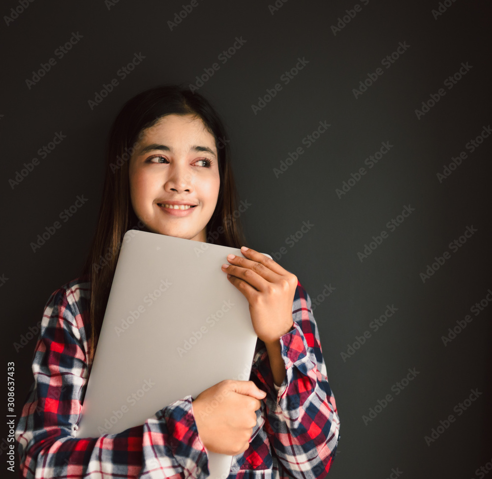 一位年轻女学生拿着电脑的画像。返校教育知识学院