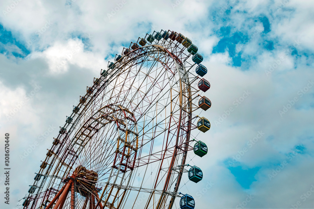 Ferris wheel on cloudy sky background vintage color