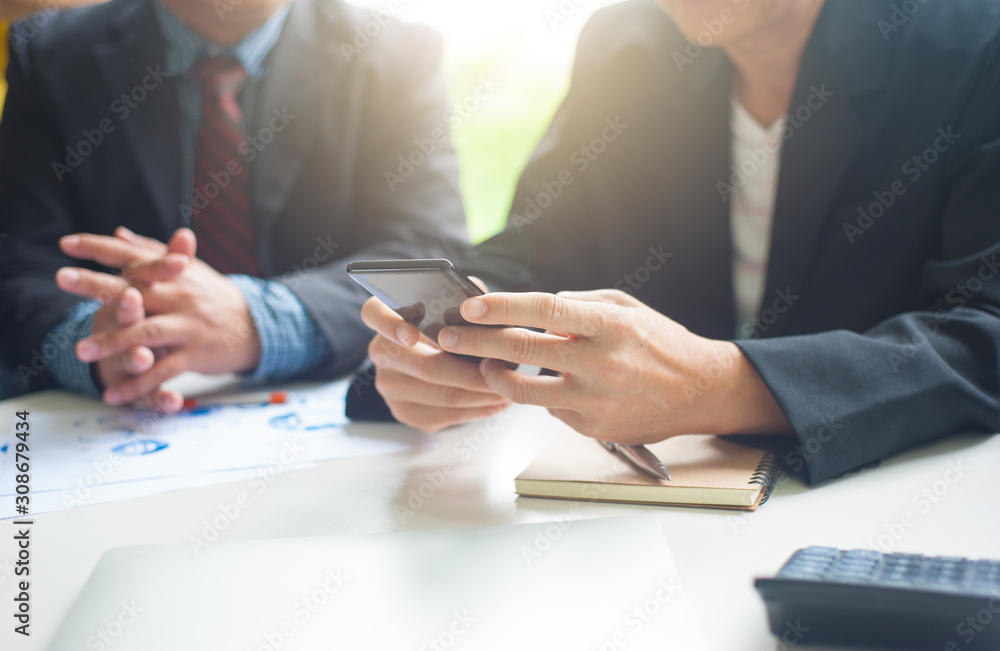 Business people use mobile phones during meetings.